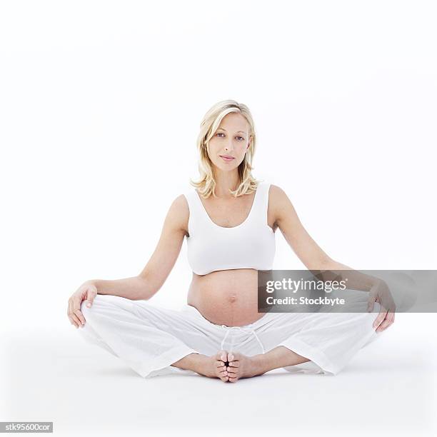 portrait of a young blonde pregnant woman sitting with her legs crossed - her stock pictures, royalty-free photos & images