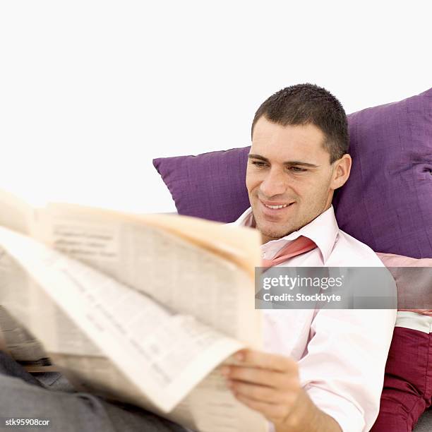 man lying on a couch and reading a newspaper - bank of canada governor stephen poloz speaks at the annual canada u s securities summit stockfoto's en -beelden