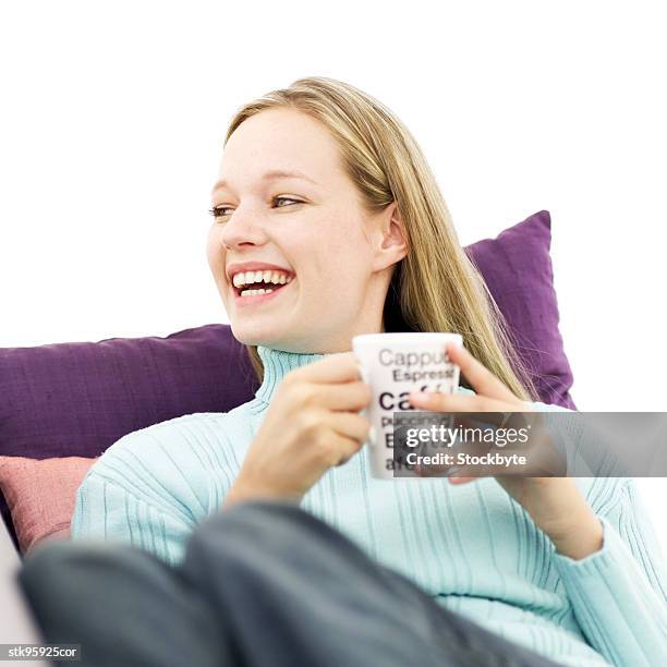 portrait of a young blonde woman holding a mug and laughing - square neckline fotografías e imágenes de stock