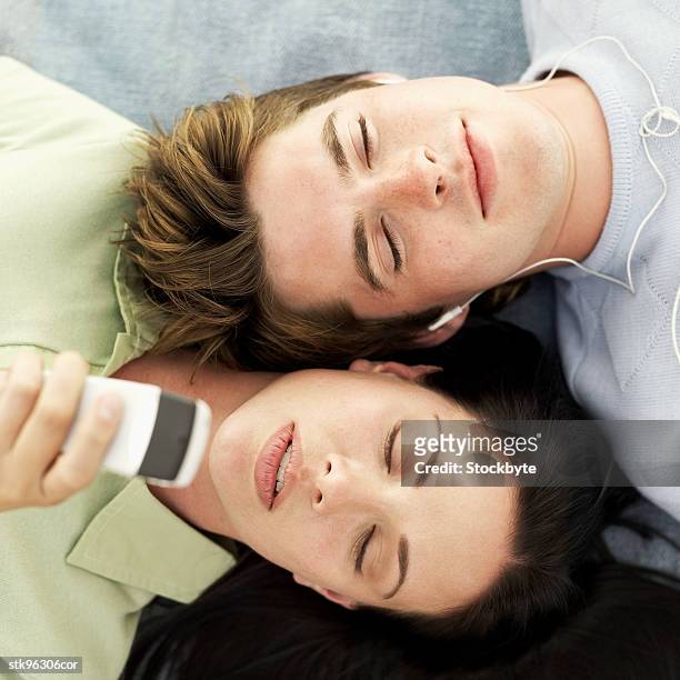 man with an mp3 and a woman with a mobile phone - recreational equipment stock pictures, royalty-free photos & images
