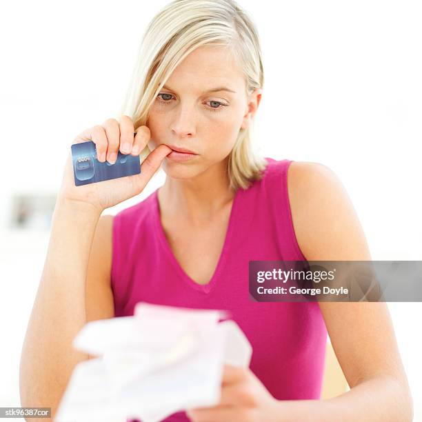 portrait of a young blonde woman going through her credit card receipts - her bildbanksfoton och bilder