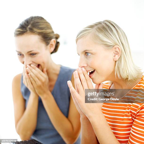 portrait of two young women holding their hands up to their face in awe - alleen mid volwassen vrouwen stockfoto's en -beelden