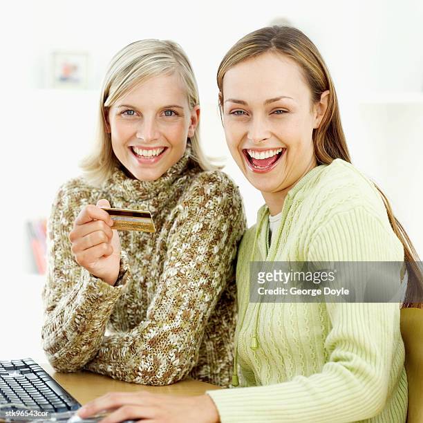 close-of two women sitting at the computer with a credit card - retail of amorepacific corp brands as south koreas biggest cosmetics makers revamps product lineup stockfoto's en -beelden