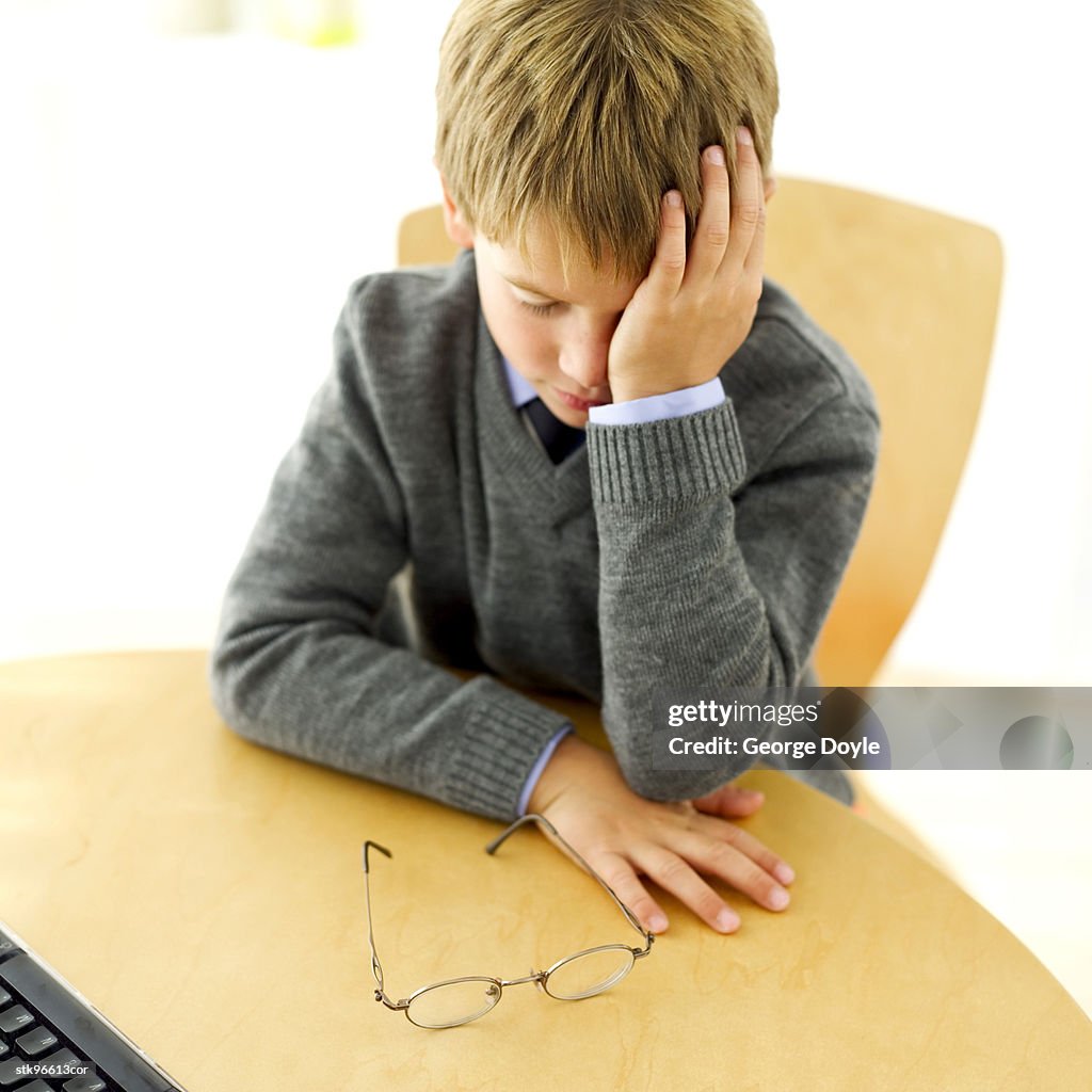 Portrait of a young boy (12-15) feeling sleepy in class