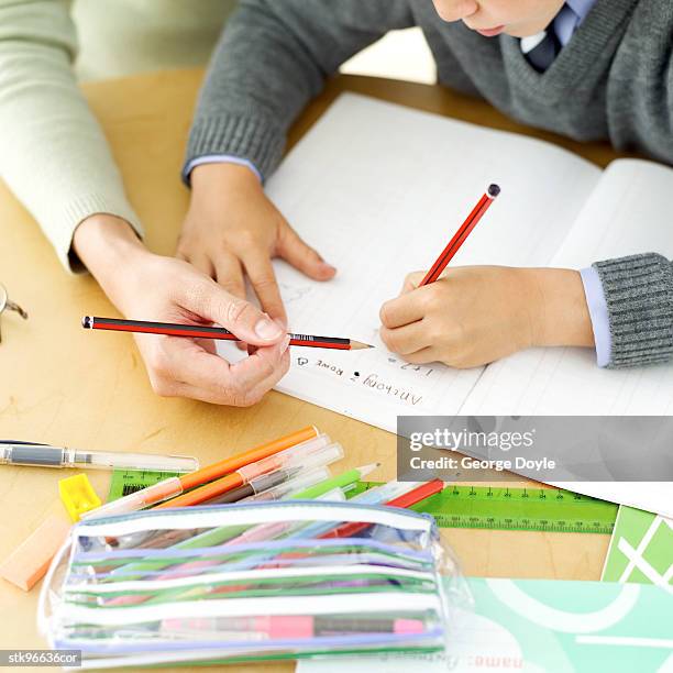 young boy being tutored by his teacher - school sweater stock pictures, royalty-free photos & images