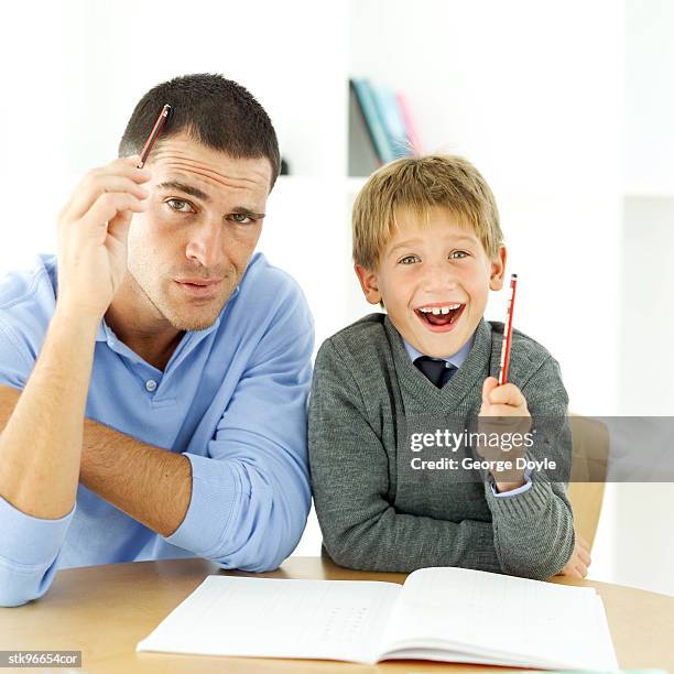 portrait of a young boy and his father studying together - middle childhood stock pictures, royalty-free photos & images