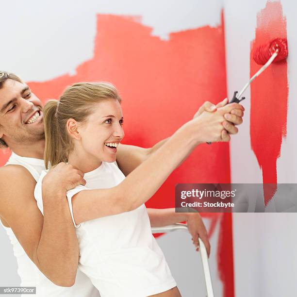 side profile of a couple painting a wall - in profile stock pictures, royalty-free photos & images