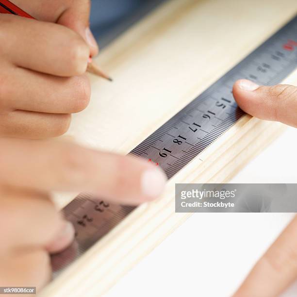 carpenter measuring and marking a plank of wood - writing instrument stock pictures, royalty-free photos & images