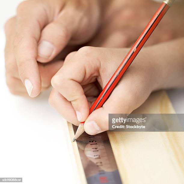 close-up of a person drawing a line with a pencil and a metal scale - radius with the cinema society brooks brothers host the new york premiere of adult beginners stockfoto's en -beelden