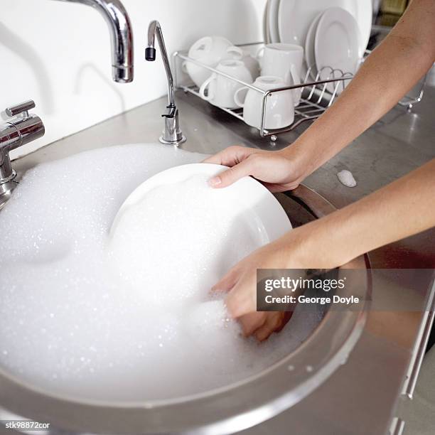 woman washing a plate in the kitchen sink - drying rack stock pictures, royalty-free photos & images