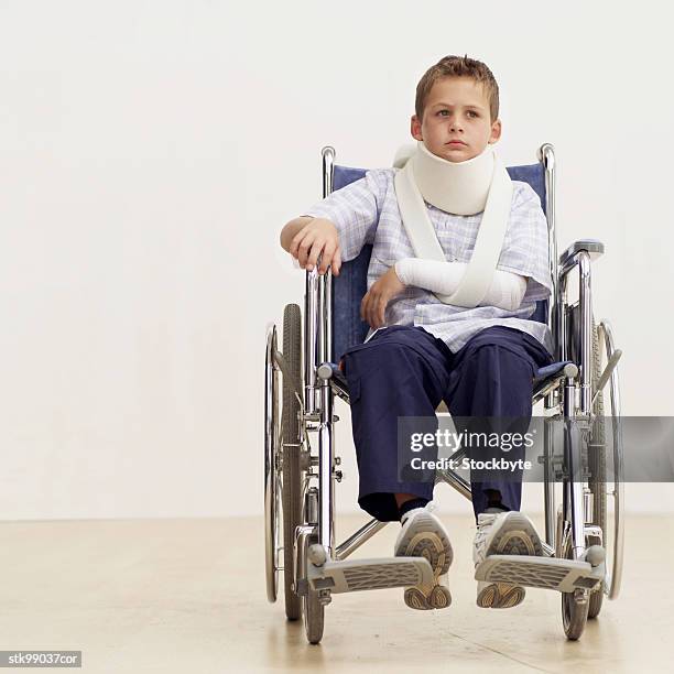 portrait of a boy (8-10) in a wheelchair wearing a neck brace - lesión de latigazo cervical fotografías e imágenes de stock