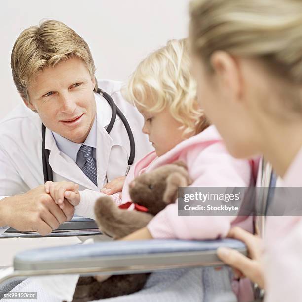 male doctor pushing a girl (8-10) in a wheelchair with a woman beside her - cast of amcs low winter sun q a with art house convergence stockfoto's en -beelden