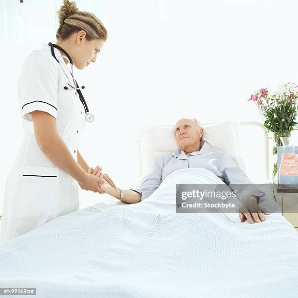 female nurse attending to an elderly male patient - screening of abramoramas hare krishna the mantra the movement and the swami who started it all arrivals stockfoto's en -beelden