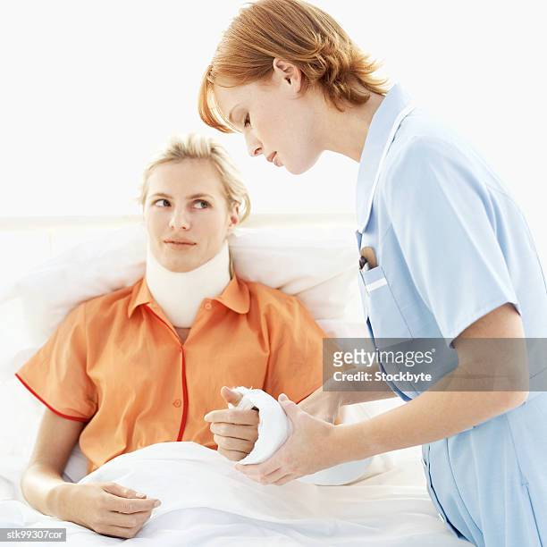 female nurse tending to a woman - lesión de latigazo cervical fotografías e imágenes de stock