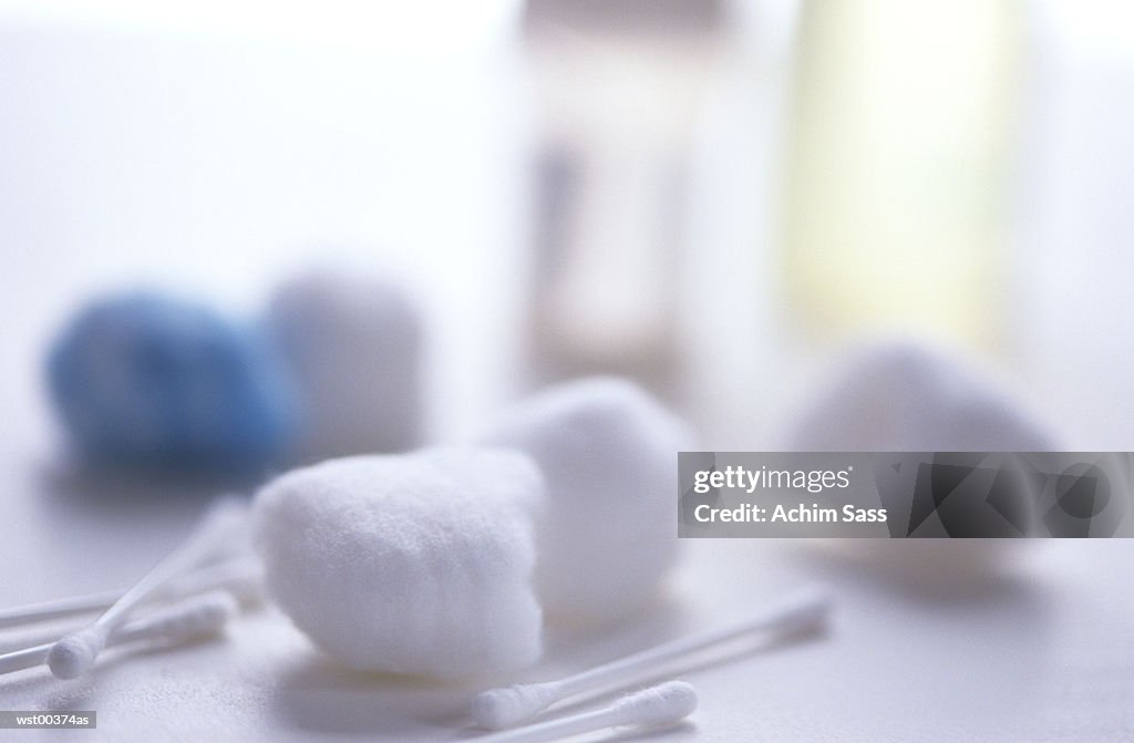 Cotton wool and cotton buds scattered on table