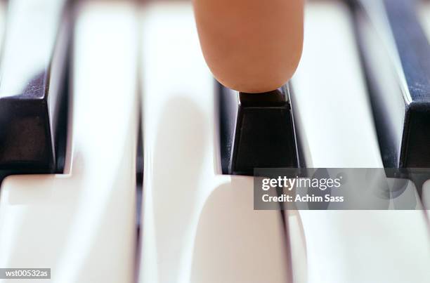 human finger on piano keys, close up - unknown gender stock pictures, royalty-free photos & images