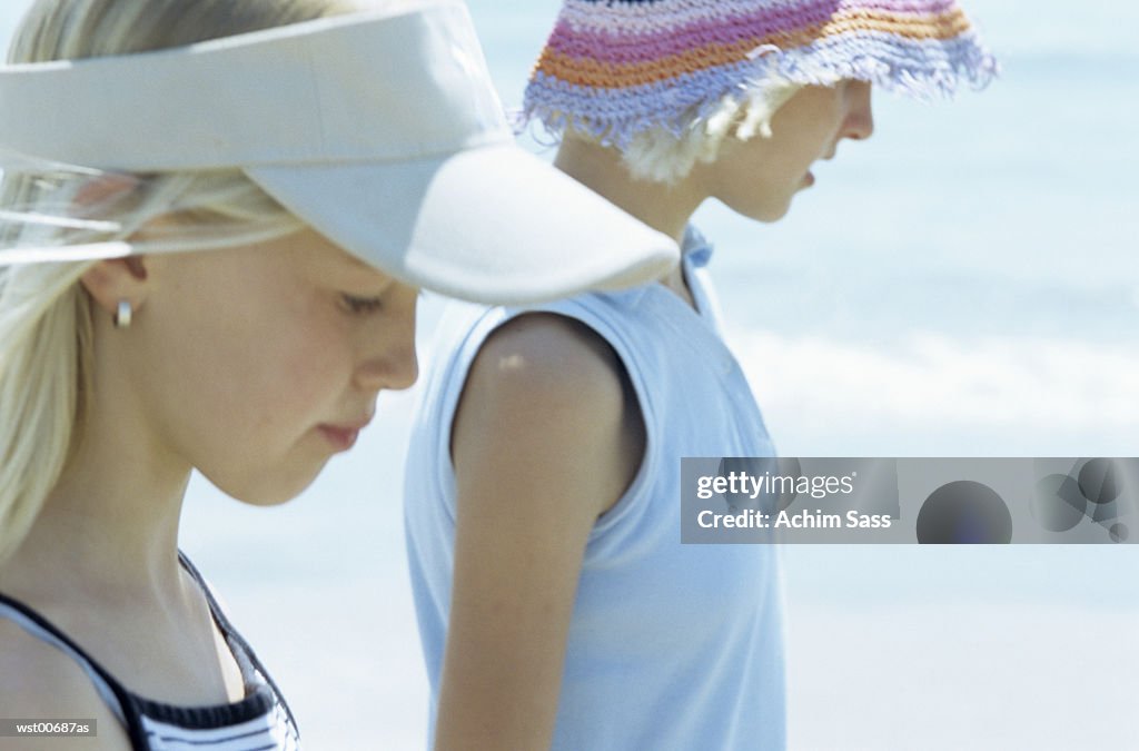 Girls walking on sandy beach, close up