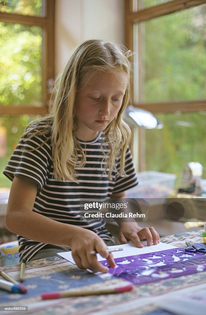 Girl drawing using stencil