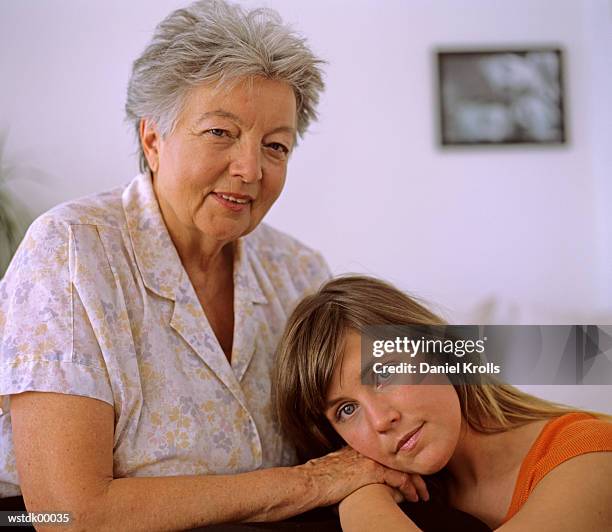senior woman sitting with grand daughter, close up - close to stock-fotos und bilder