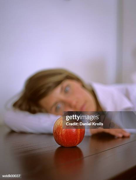 woman sitting pensively, focus on apple - daniel daniel stock pictures, royalty-free photos & images