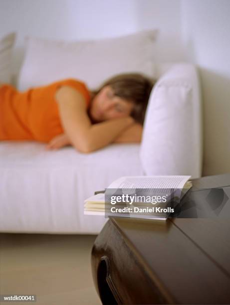 woman lying on sofa, focus on open book - daniel daniel stock pictures, royalty-free photos & images