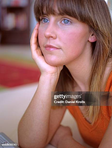 young woman sitting pensively, close up - close to stock-fotos und bilder