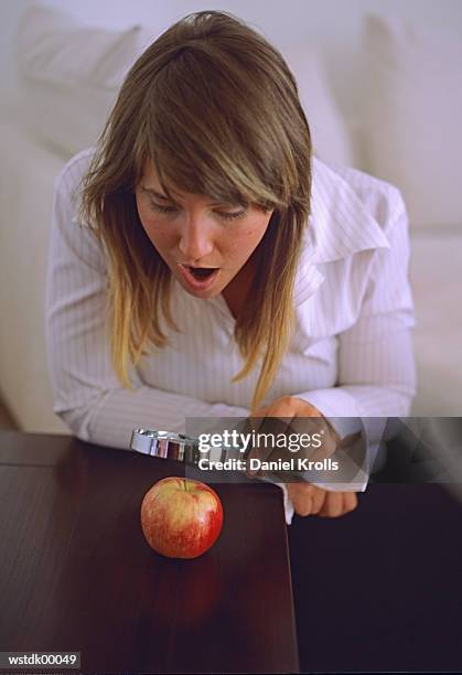 woman looking at apple through magnifying glass - daniel fotografías e imágenes de stock