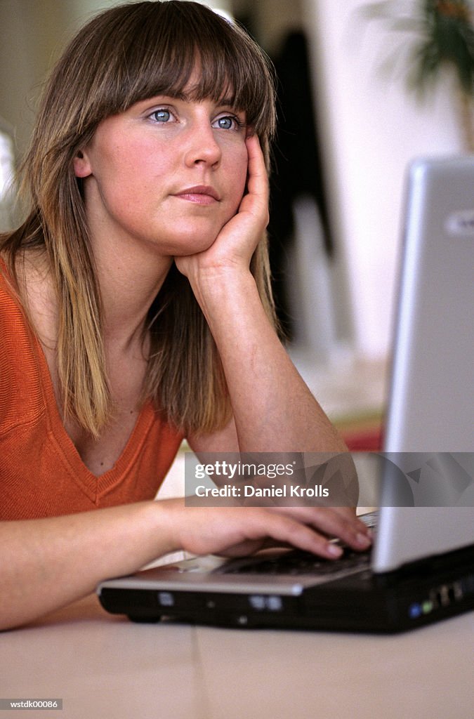 Woman with laptop, looking away