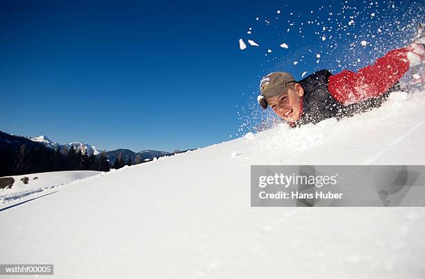 boy sliding down snow slope - water form stock pictures, royalty-free photos & images