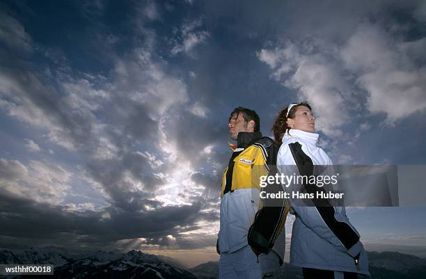 couple standing back to back - next to bildbanksfoton och bilder