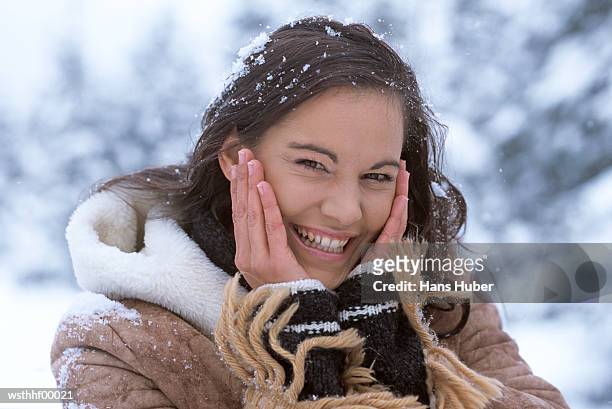 woman in snow with hands on face - alleen mid volwassen vrouwen stockfoto's en -beelden