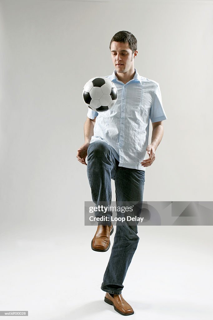 Man keeping football in the air with his knee