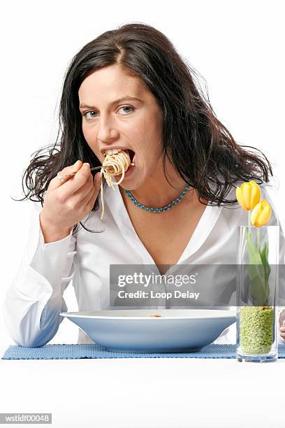 young woman eating bowl of spaghetti with fork, portrait - outof stock pictures, royalty-free photos & images