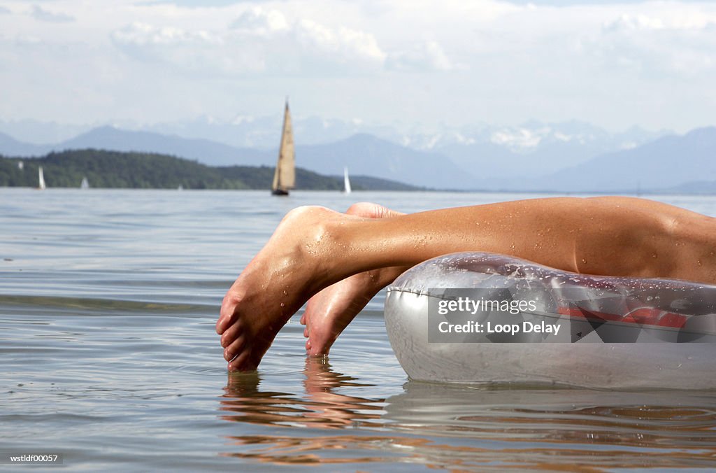 Woman on air mattress, lying on front, Lake Starnberg, Bavaria, Germany