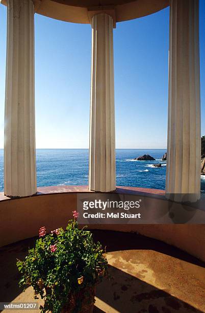 view of ocean through three columns, jardi botanic mar i murtra, blanes, costa brava, catalonia, spain - of stockfoto's en -beelden