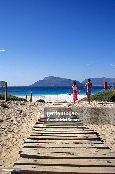 two women walking towards beach, south africa - premiere of beard collins shores productions a very sordid wedding q a stockfoto's en -beelden