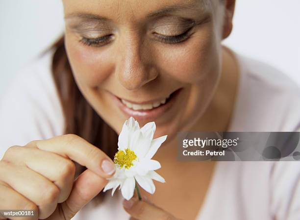woman plucking petals of flower - alleen mid volwassen vrouwen stockfoto's en -beelden