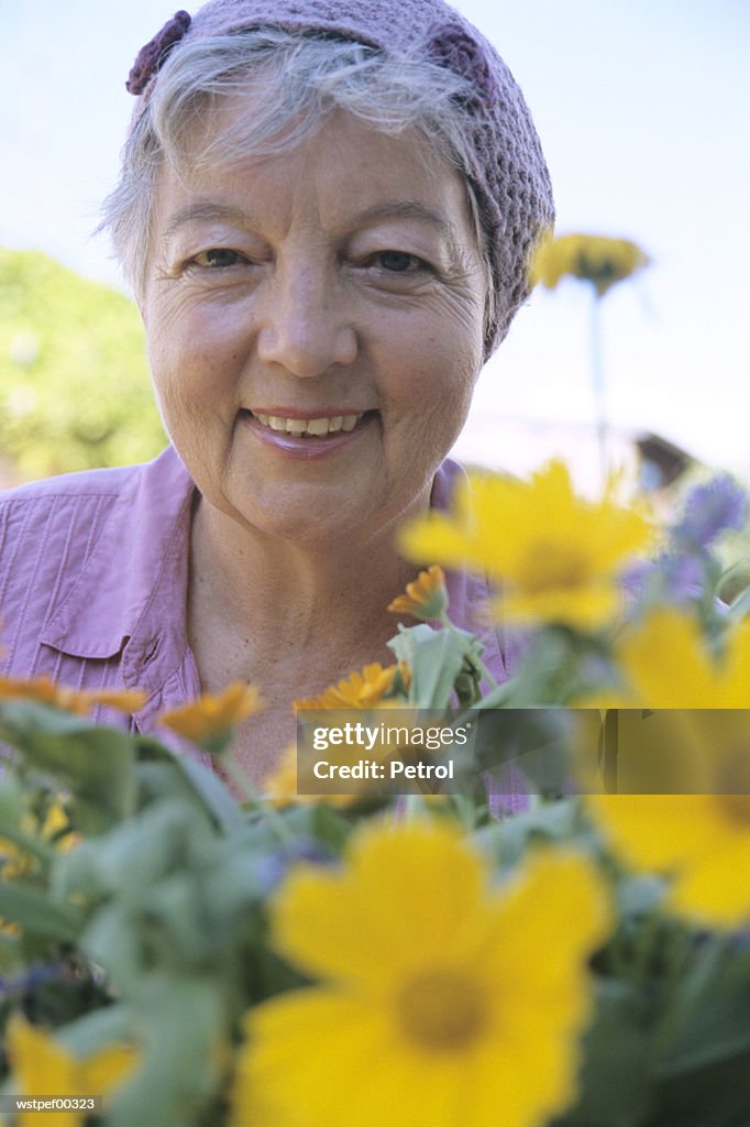 Senior woman in front of flowers, close up