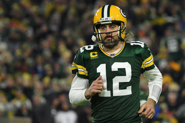 Aaron Rodgers of the Green Bay Packers runs onto the field before the NFL game against the Chicago Bears at Lambeau Field on December 12, 2021 in...