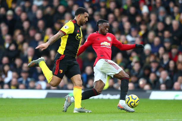 Aaron WanBissaka of Manchester United battles for possession with Troy Deeney of Watford during the Premier League match between Watford FC and...