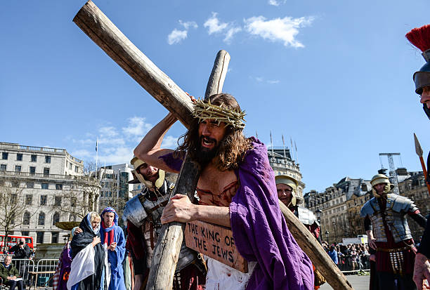 Actor James Burke-Dunsmore carries the crucifix whilst playing Jesus during The Wintershall's 'The Passion of Jesus' in front of crowds on Good...