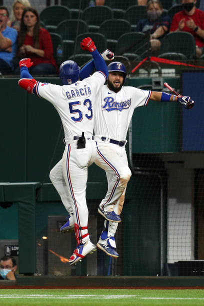 Adolis Garcia of the Texas Rangers celebrates with Isiah Kiner-Falefa after a solo home run to tie the game against the Seattle Mariners in the...