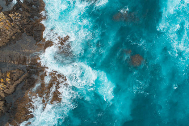 vista aérea de las olas salpicando en la playa. - marea fotografías e imágenes de stock