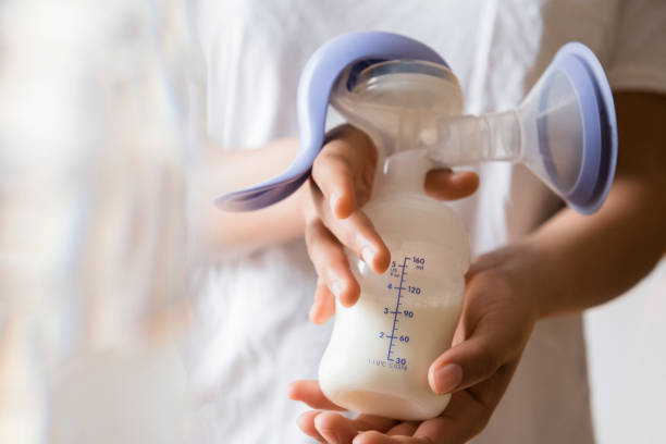 african american woman holding milk in breast pump - breast feeding bottle stock pictures, royalty-free photos & images