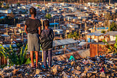 African little girls standing in trash and looking at Kibera slum, Kenya, East Africa