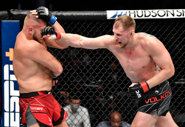 Alexander Volkov of Russia punches Marcin Tybura of Poland in a heavyweight fight during the UFC 267 event at Etihad Arena on October 30, 2021 in Yas...