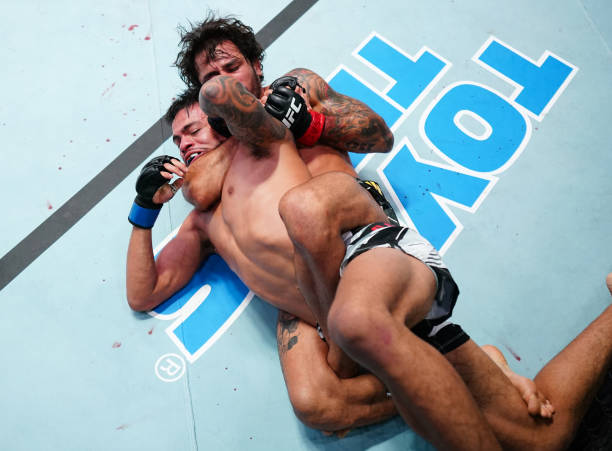 Alexandre Pantoja of Brazil secures a rear choke submission against Brandon Royval in a flyweight fight during the UFC Fight Night event at UFC APEX...