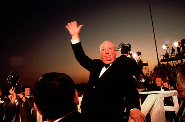 Alfred Hitchcock waves to the crowds upon his arrival at the Academy Awards Ceremony of 1968.