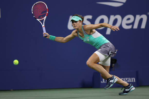 Alize Cornet of France reaches to return a shot against Emma Raducanu of Great Britain in their Women's Singles First Round match on Day Two of the...