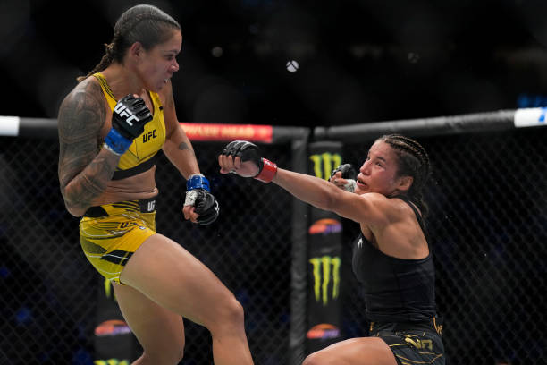 Amanda Nunes of Brazil knocks down Julianna Pena in the UFC bantamweight championship fight during the UFC 277 event at American Airlines Center on...